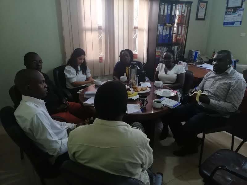 Stakeholders seated around a table during a research meeting